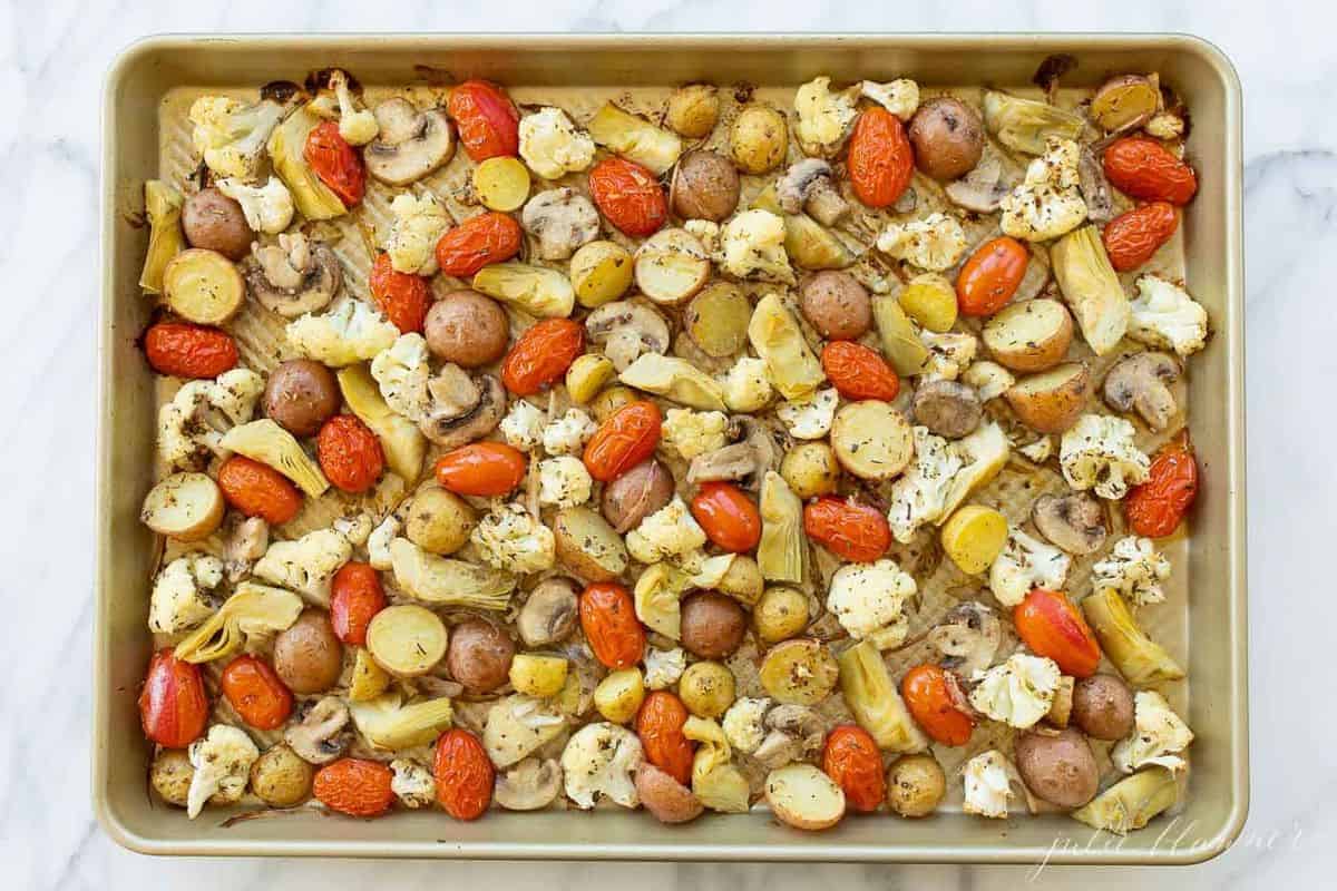 Gold sheet pan filled with seasoned roasted Italian vegetables, ready for the oven. #italianvegetables