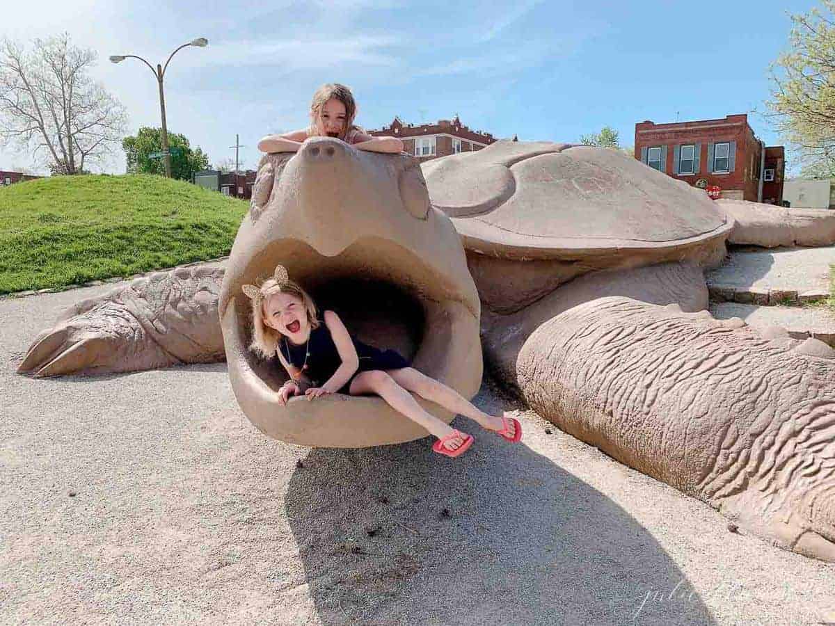 St. Louis turtle park sculpture with little girls playing inside the turtle's mouth.