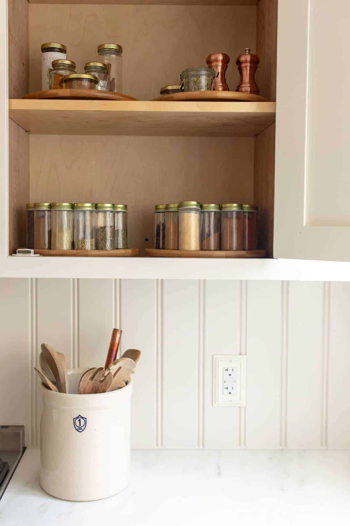 Spice jars in a kitchen cabinet.