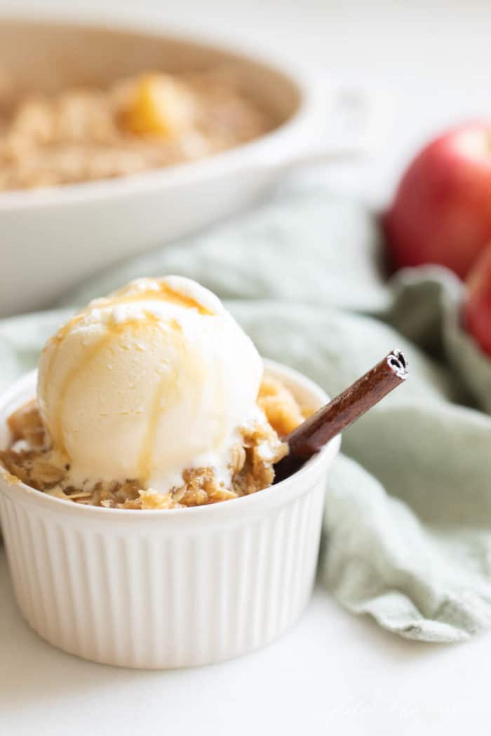 apple crisp in bowl with baking dish in background