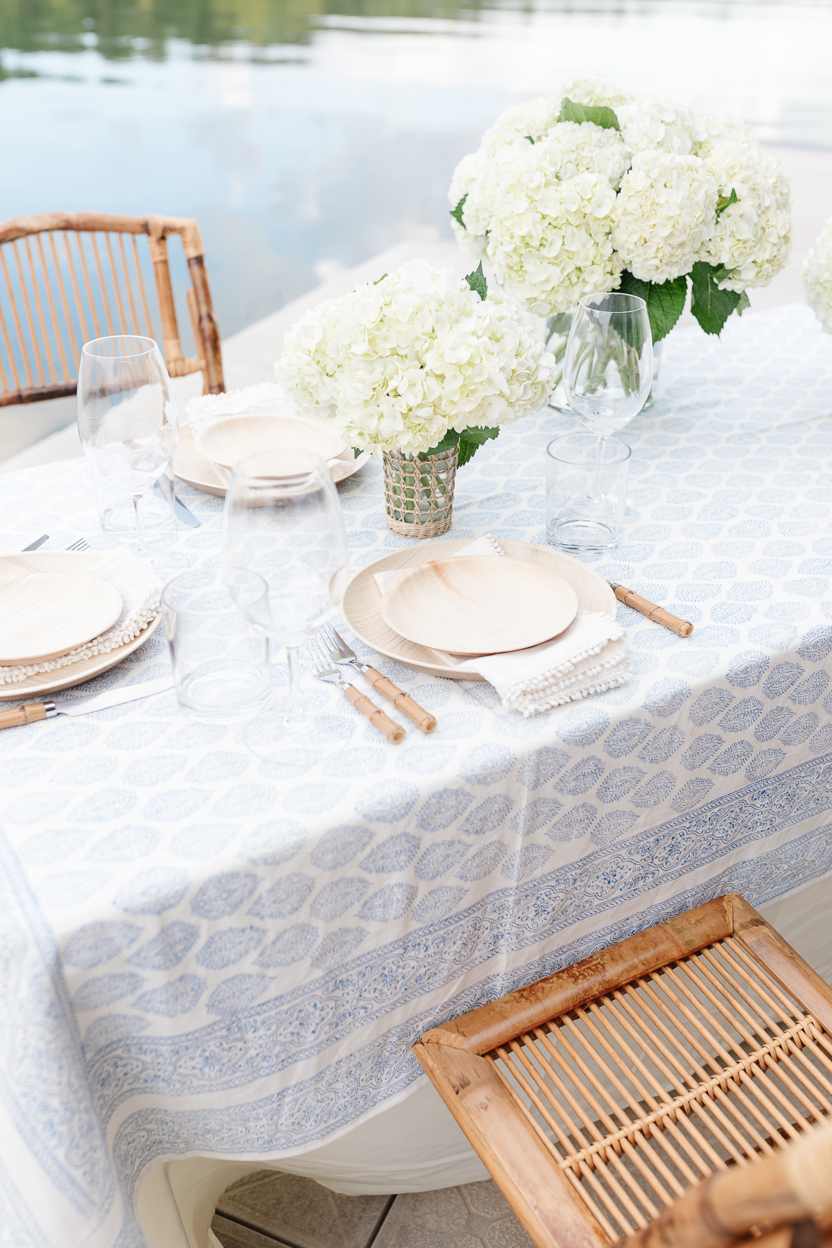 A table with white flowers on it, covered in a blue and white block print table cloth.