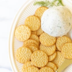 A white plate filled with crackers and homemade Boursin cheese.