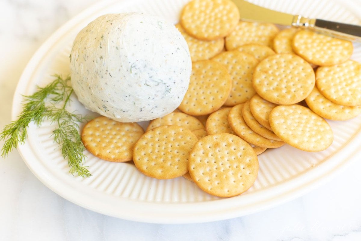 A white plate filled with crackers and homemade Boursin cheese.
