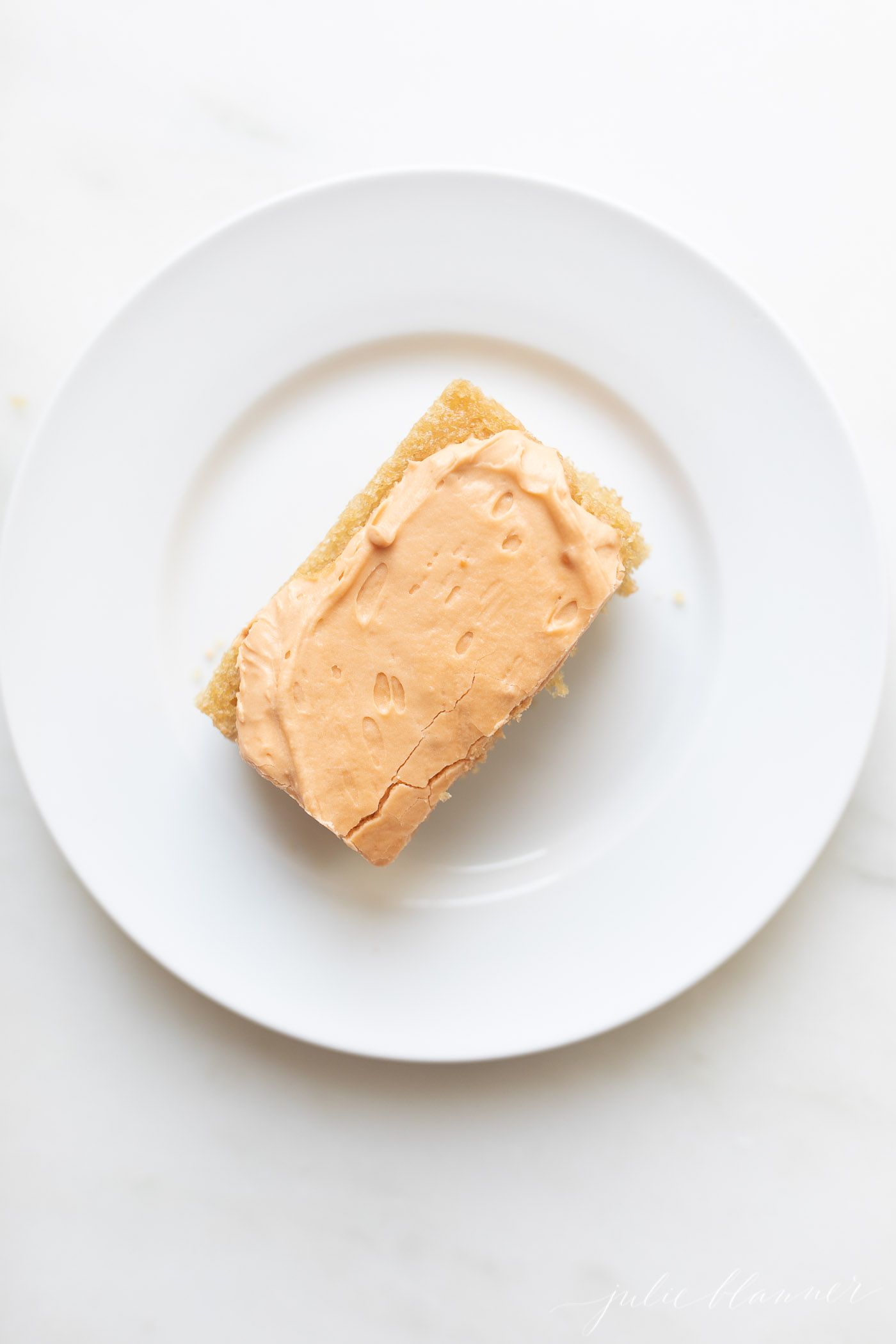 A slice of butterscotch cake on a white plate.