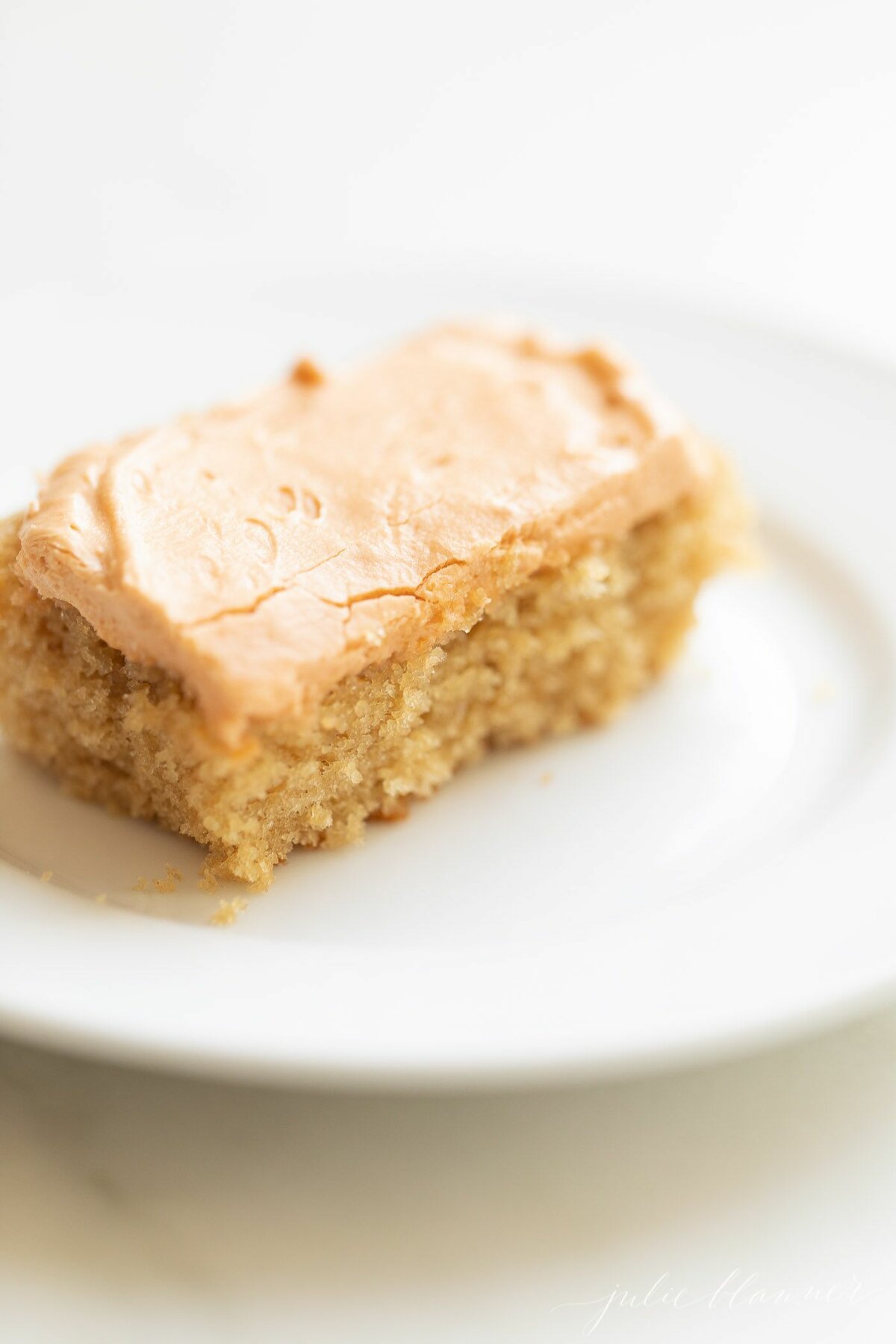 A slice of butterscotch cake on a white plate.