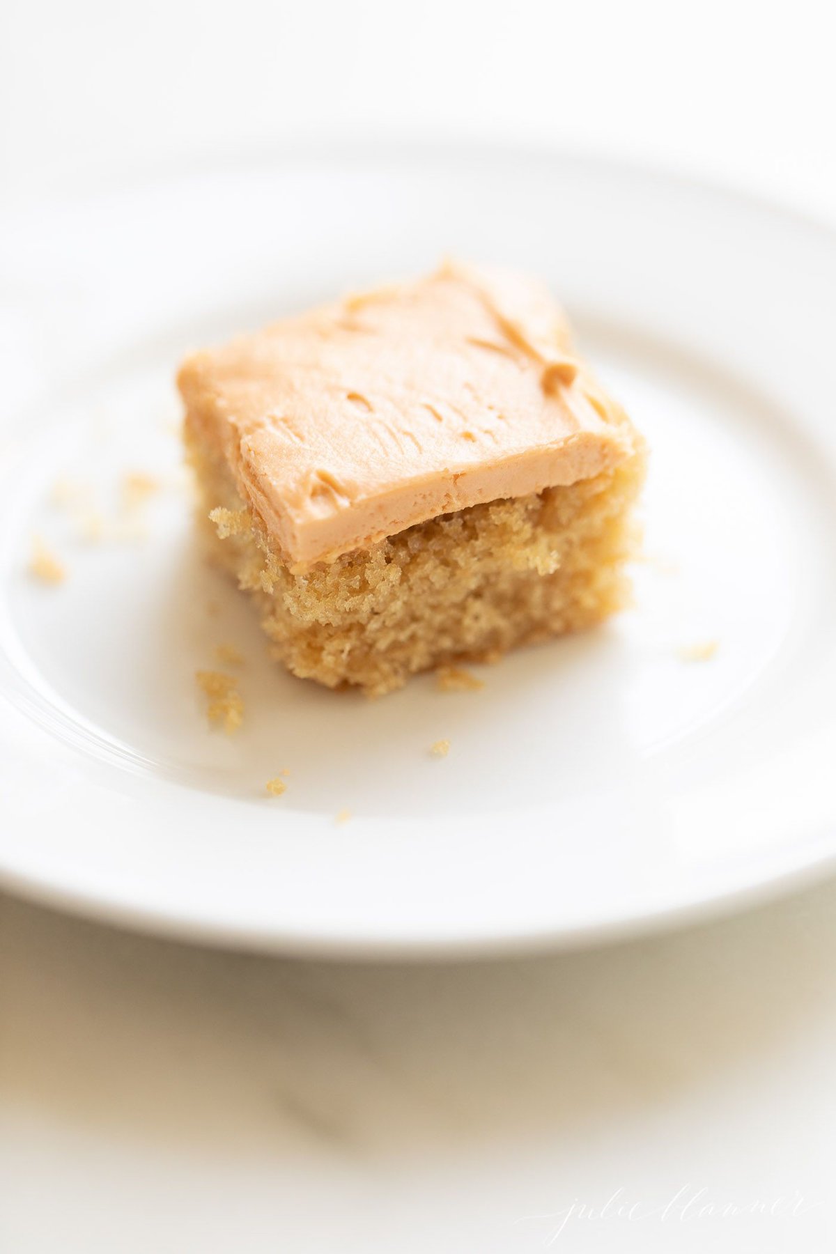 A slice of butterscotch cake on a white plate.