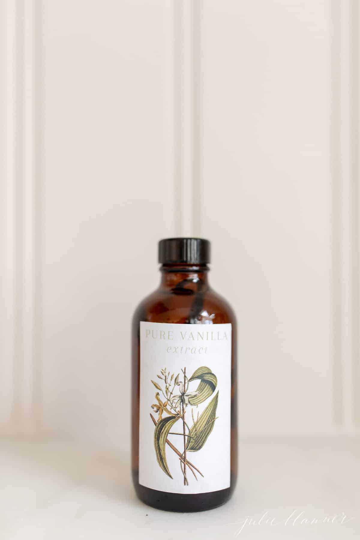 A brown glass bottle of vanilla extract on a white surface.