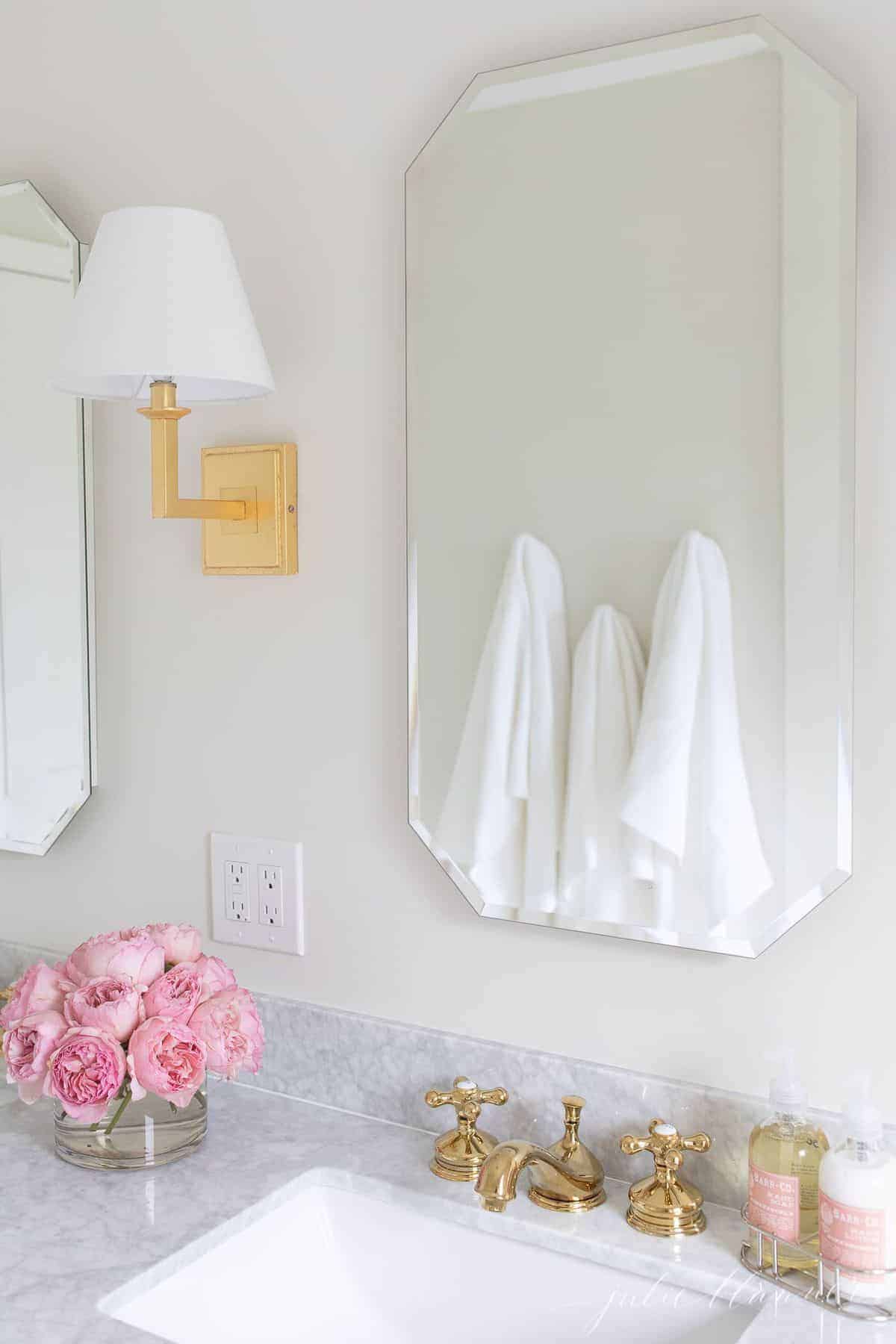 Mirrored medicine cabinets above a marble vanity. 