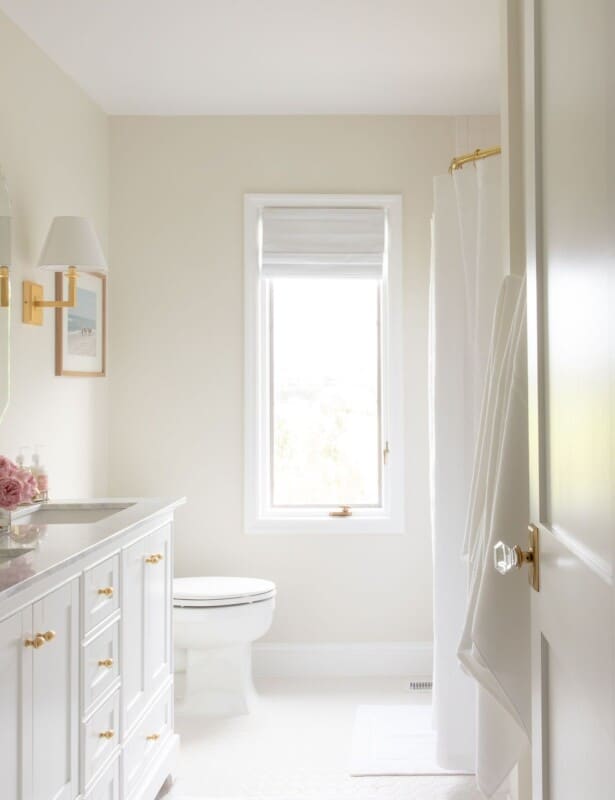 A white bathroom with gold accents.