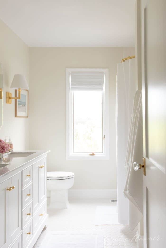 A white bathroom with gold accents. 