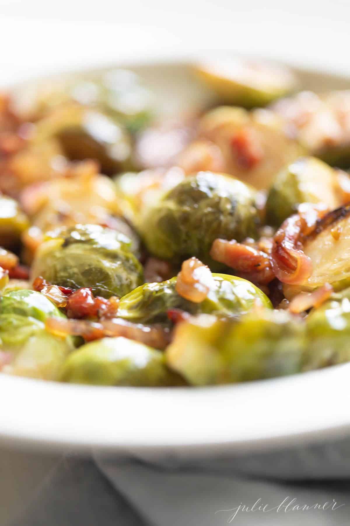 A close up of crispy brussel sprouts on a white plate.