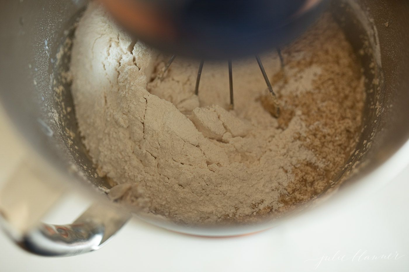 Ingredients for a peanut butter cake, inside the bowl of a stand mixer.