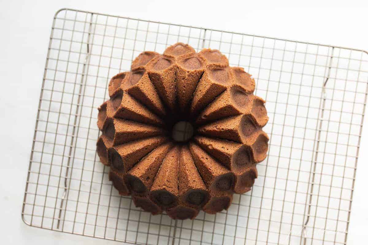 Perfectly formed round bundt cake, placed on a metal baking rack.