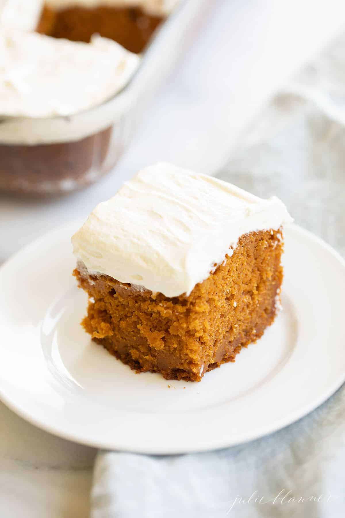 A slice of pumpkin cake on a white plate.