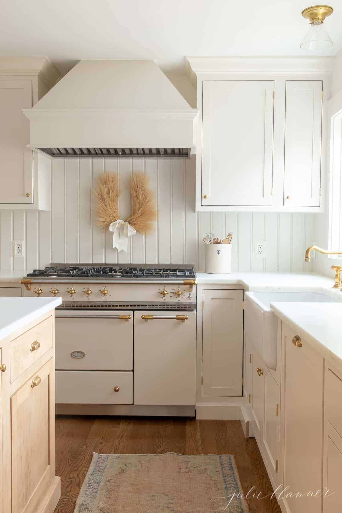 laurel wreath made of wheat with ivory ribbon hanging in kitchen