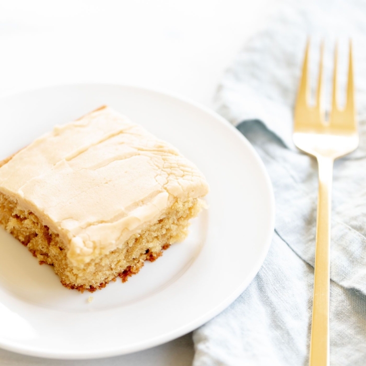 A slice of peanut butter cake on a white plate.