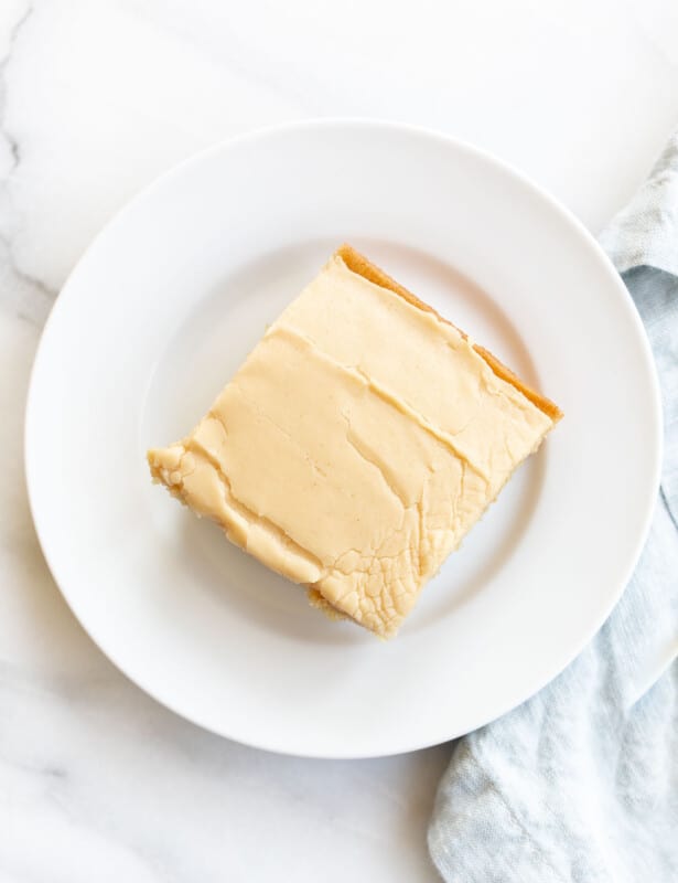 peanut butter cake with peanut butter icing on a plate with a blue napkin