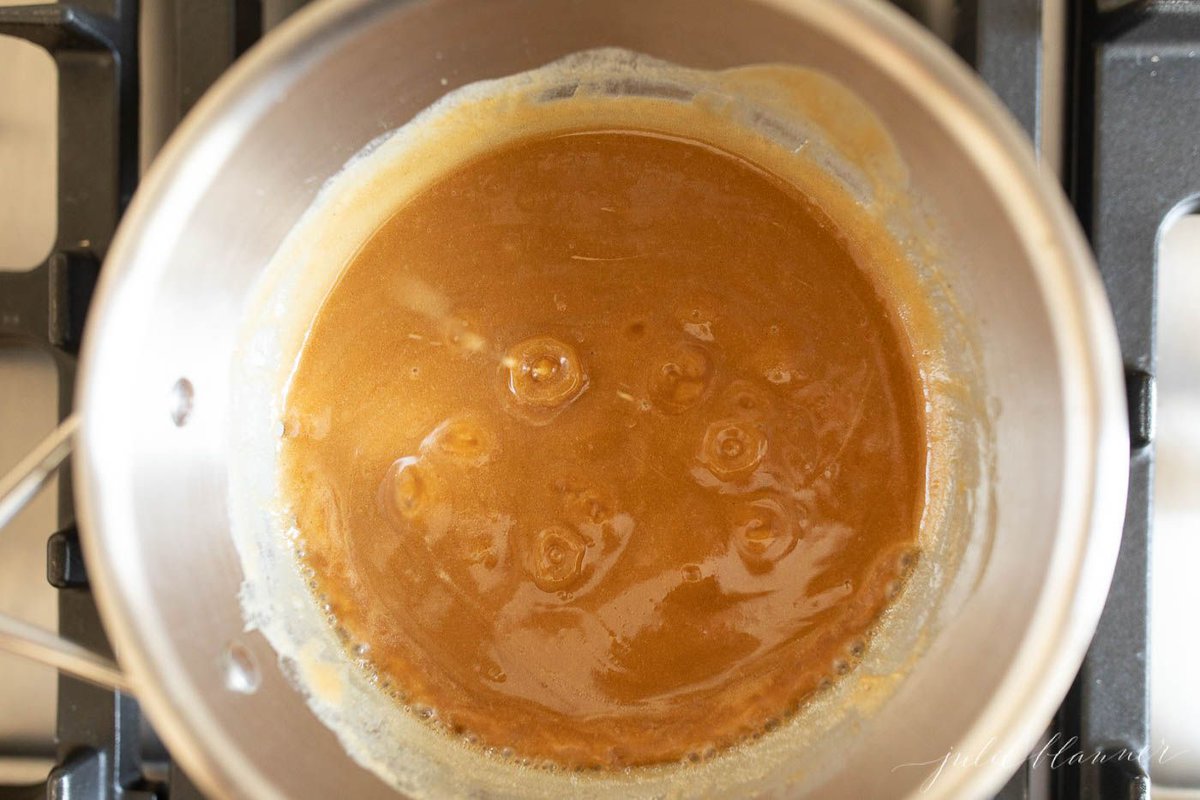 Peanut butter frosting ingredients in a silver sauce pan.