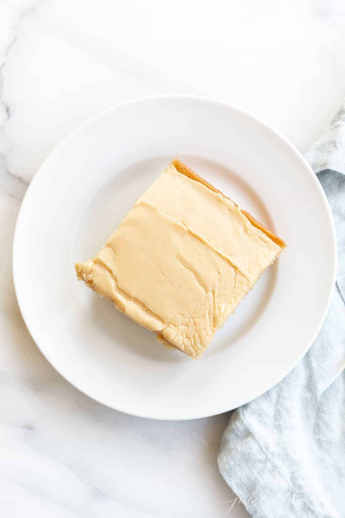 peanut butter cake with peanut butter icing on a plate with a blue napkin