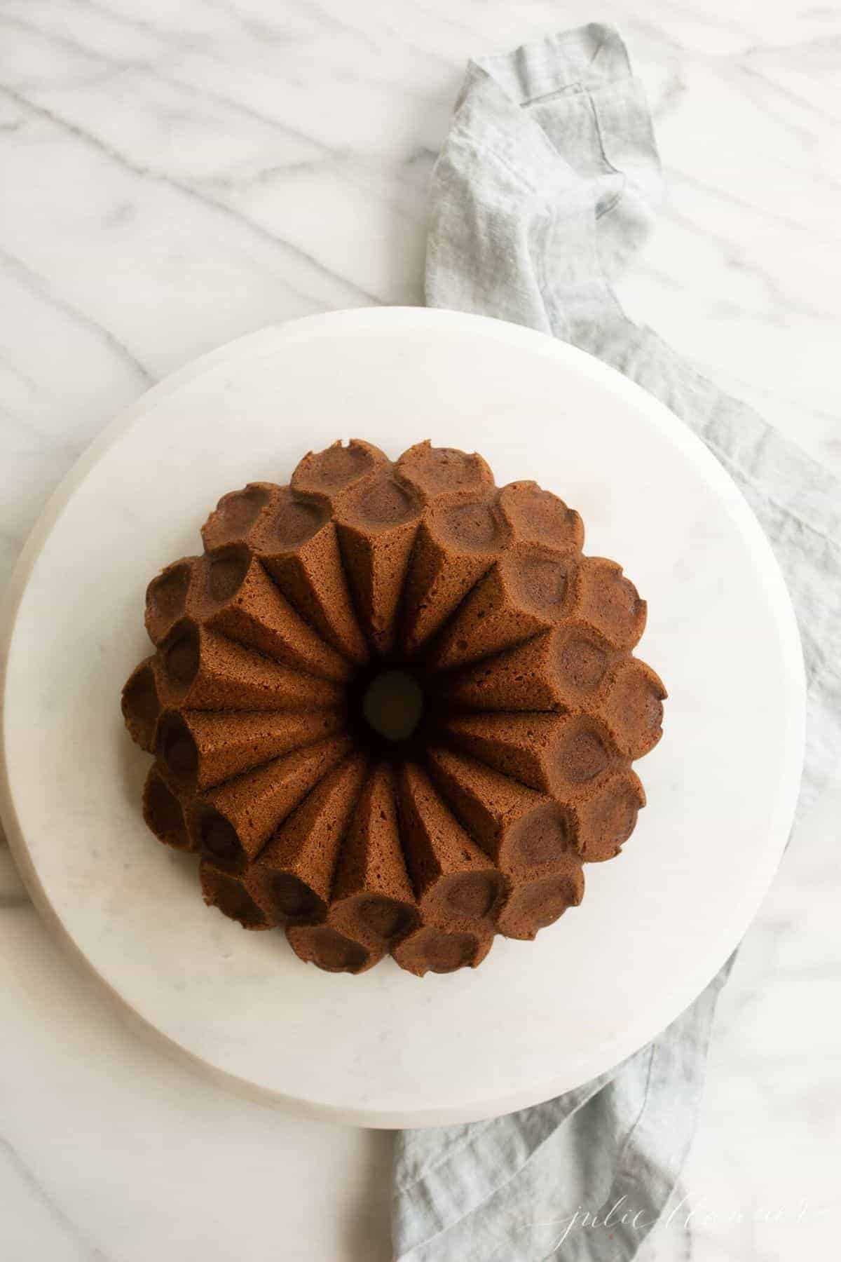 Looking down onto a bundt cake, placed on a marble platter.