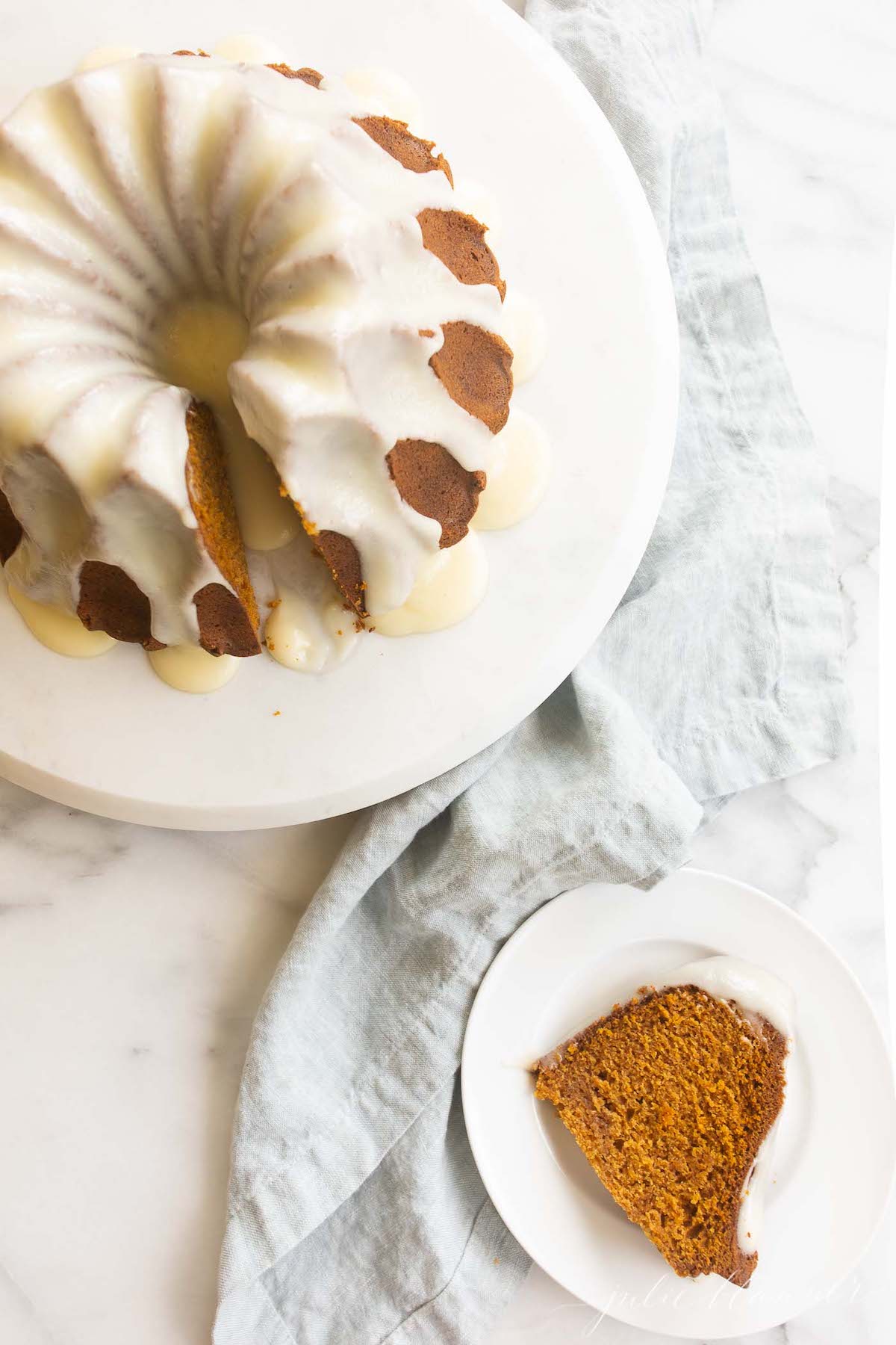 A slice of pumpkin bundt cake, with the full cake in the background.