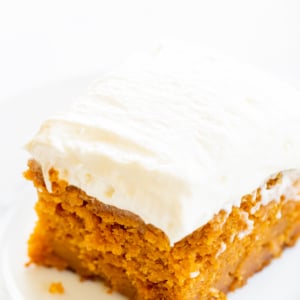 A slice of pumpkin cake on a white plate.