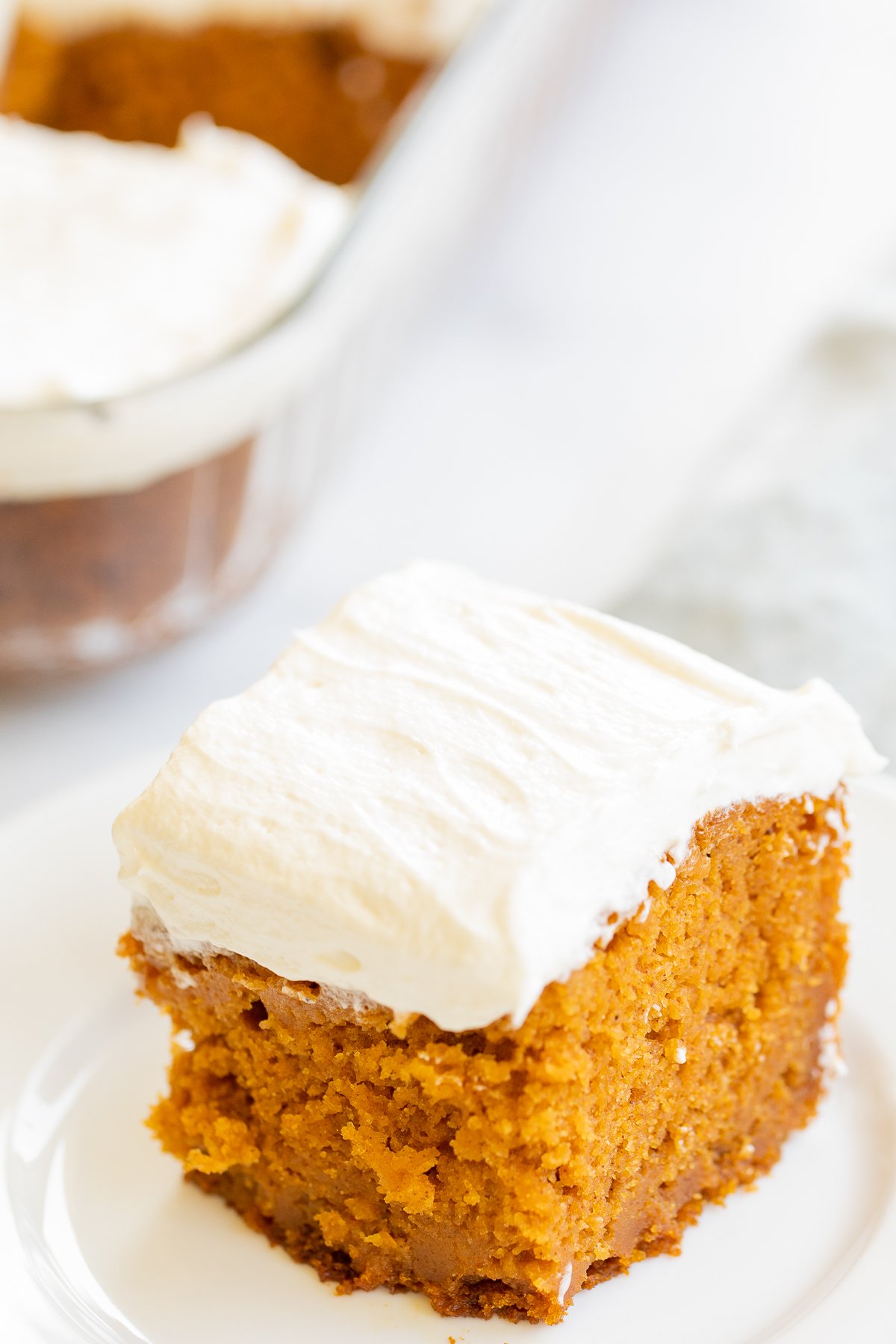 A slice of pumpkin cake on a white plate.