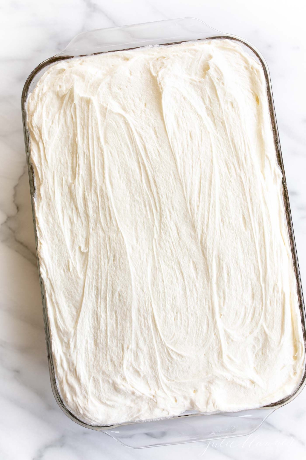 A pumpkin cake recipe, baked in a 9x13 inch glass pan, topped with cream cheese frosting