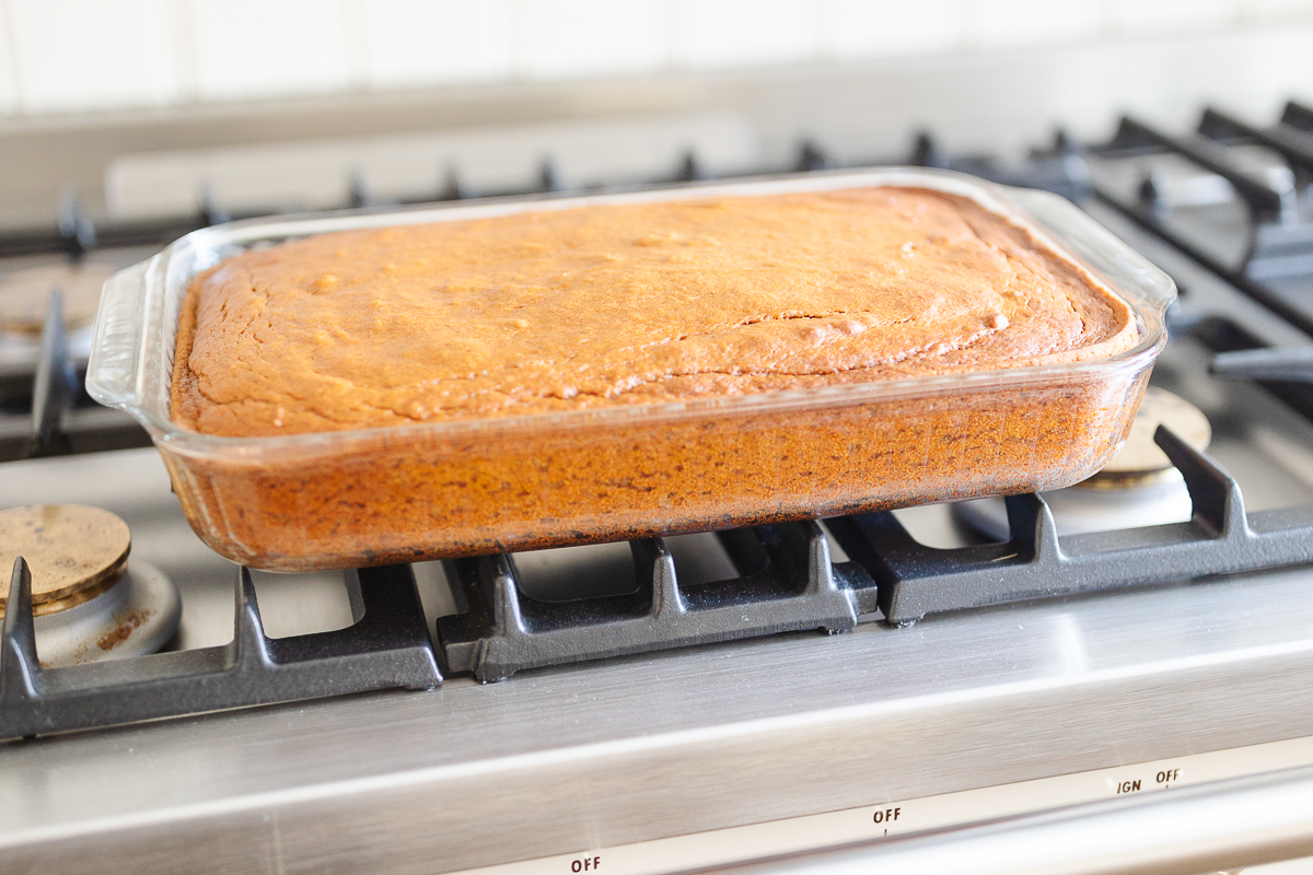 A loaf of pumpkin bread in a glass pan on a stove.