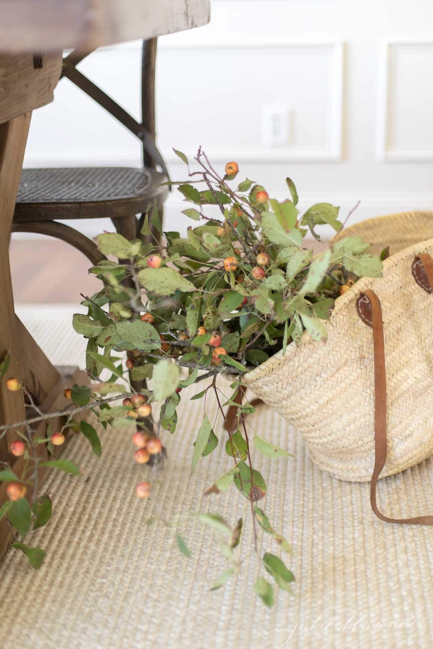 Straw tote full of fall branches with berries. 