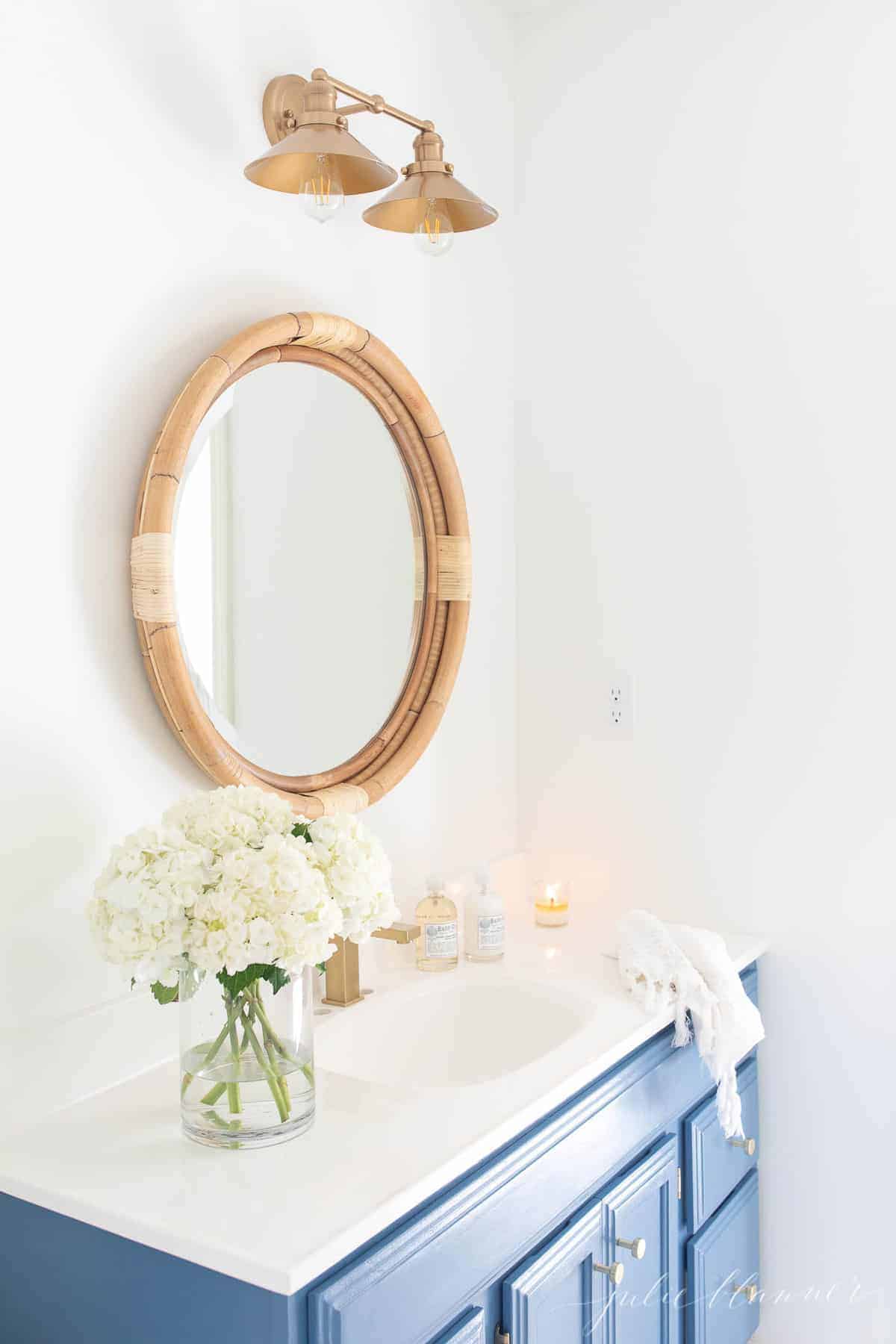 blue vanity in nautical bath with double nautical light fixture