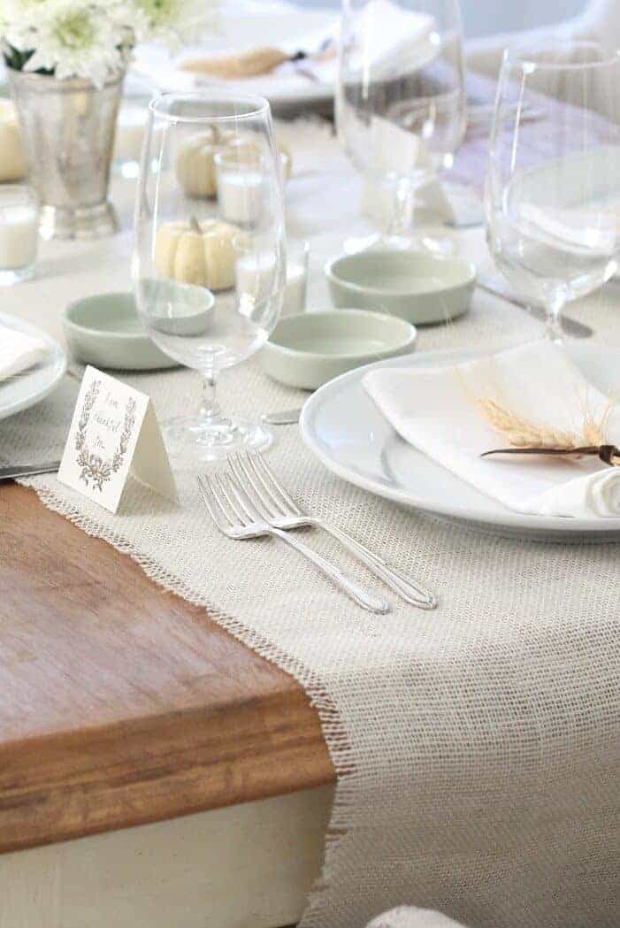 Table set for Thanksgiving, wheat on top of napkins at place setting.