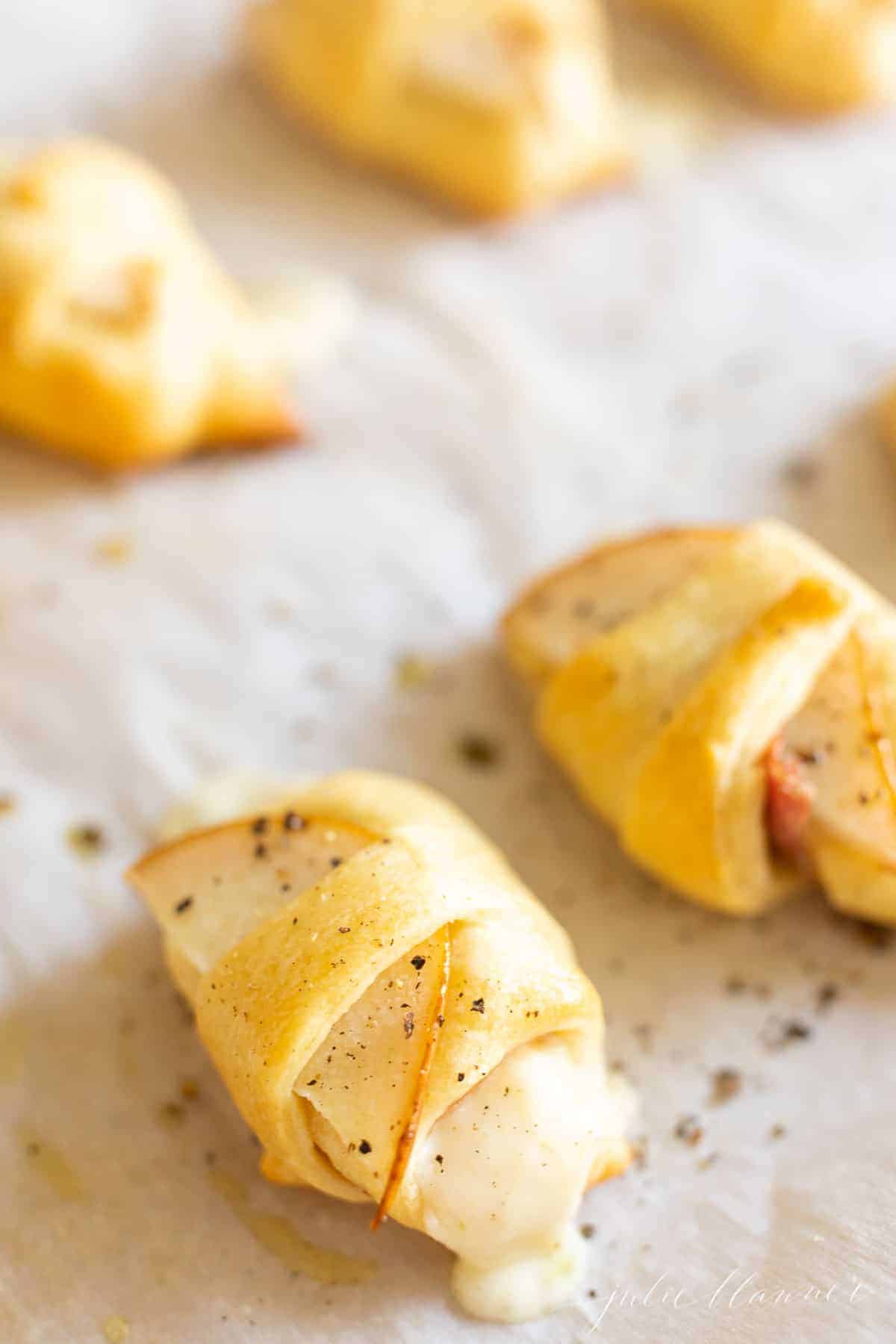 Baked cheese pear crescent roll on parchment paper.