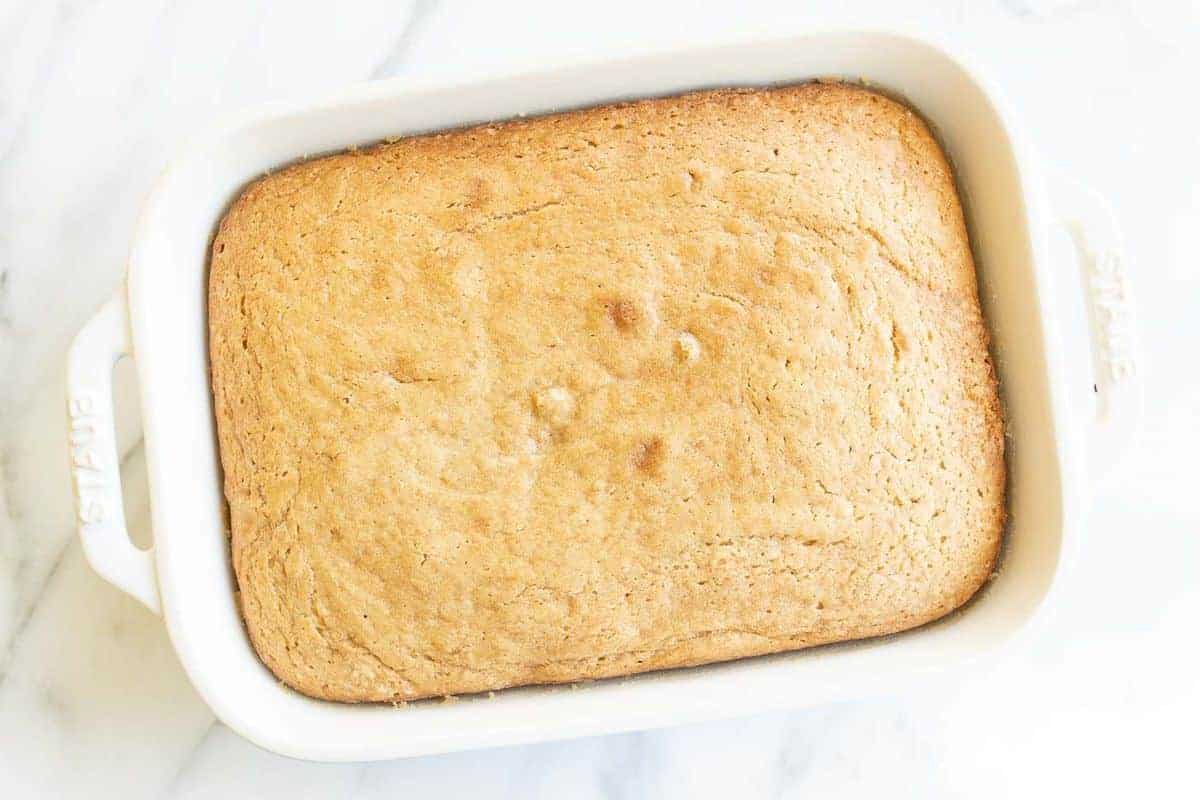 White baking dish with a fully baked cake inside.