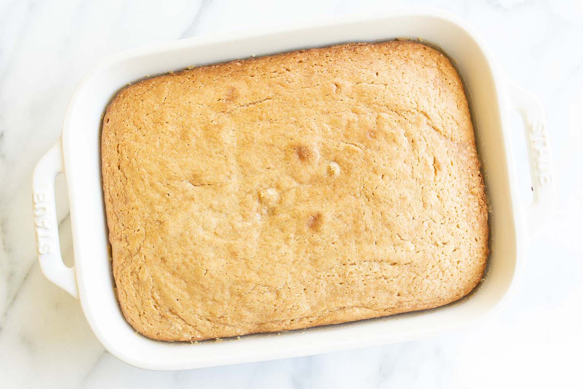 A white cake pan with a biscoff cake recipe in it.