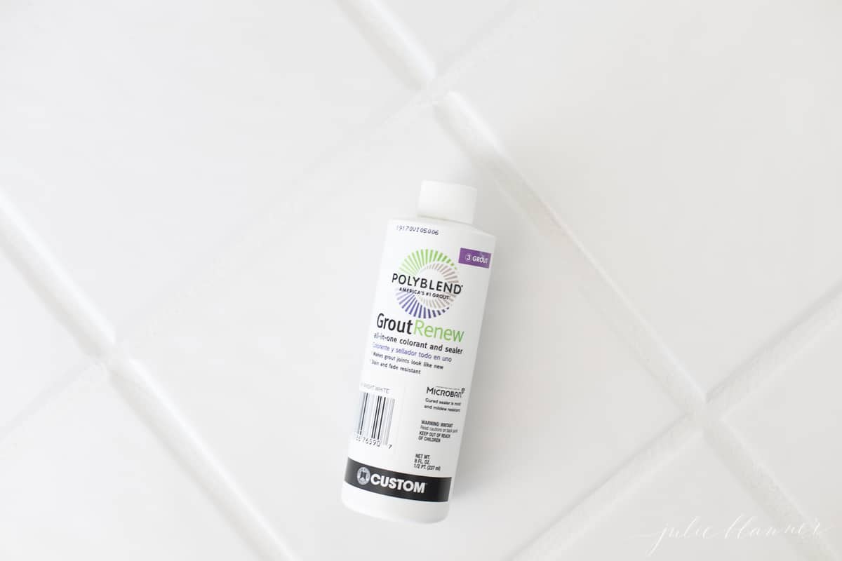 bright white tile grout stain in a bottle pictured on top of tile with newly refreshed grout lines.