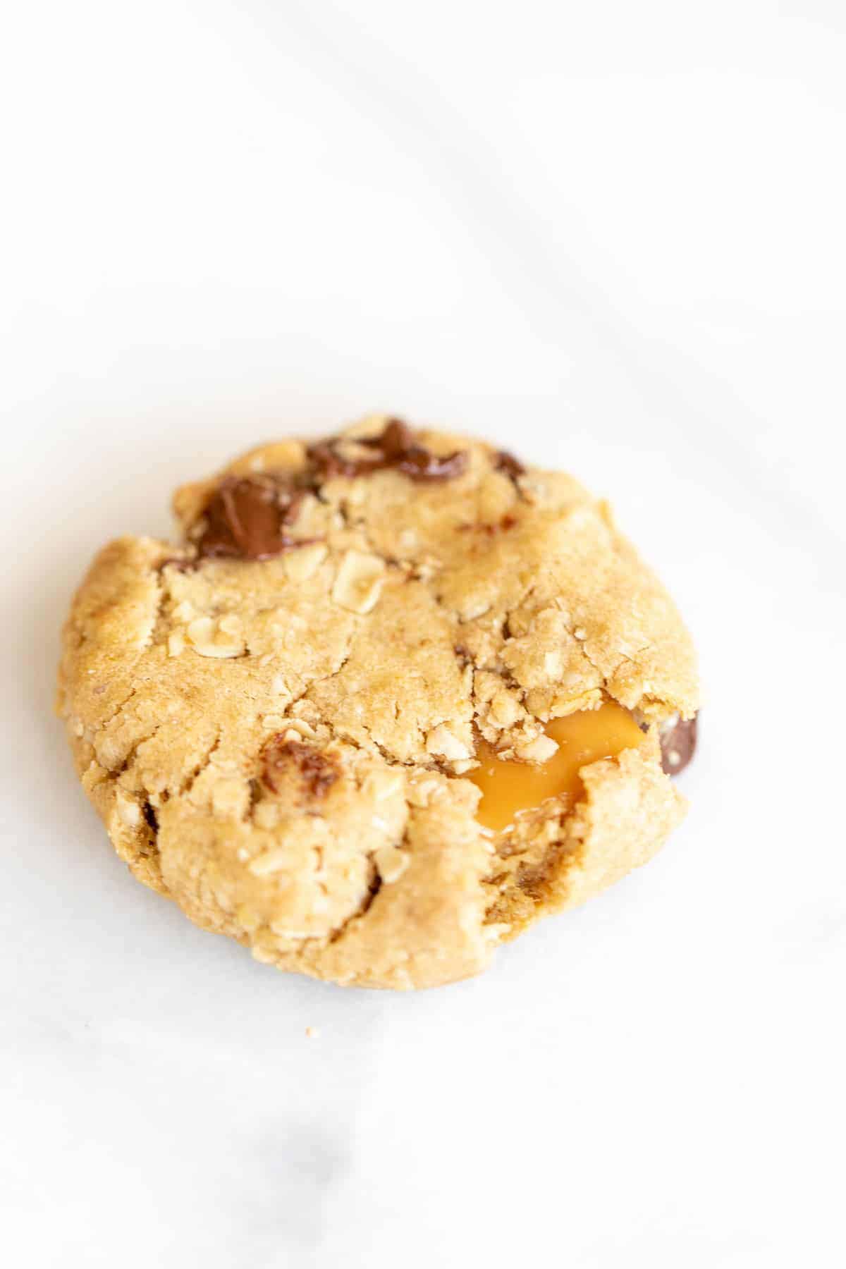 Get the delicious buttery oatmeal texture with gooey caramel of a carmelita bar wrapped into carmelita cookies! You can make a huge batch in just 20 minutes and they are a hit with everyone who tries them! They are perfect fall cookies and great for holiday exchanges and Christmas treats! brown sugar oatmeal cookie with chocolate chips stuff with caramel