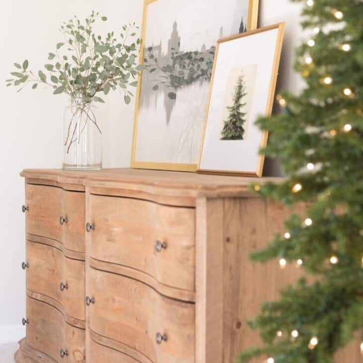 A soft wood dresser in a bedroom with simple Christmas decor.