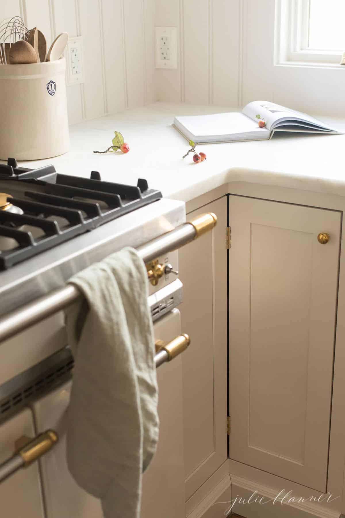 French range with white cabinets, open cookbook.