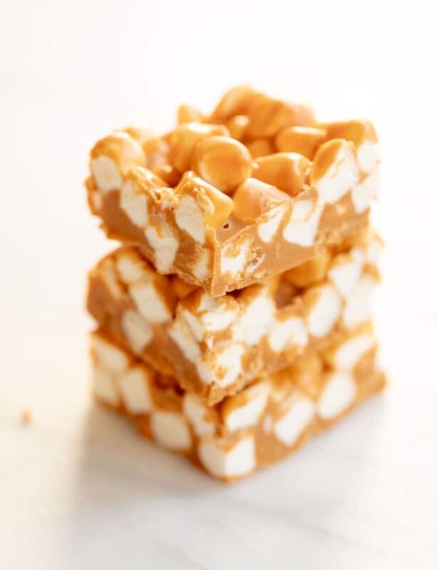 Stack of three homemade no bake butterscotch candy bars on a marble surface.