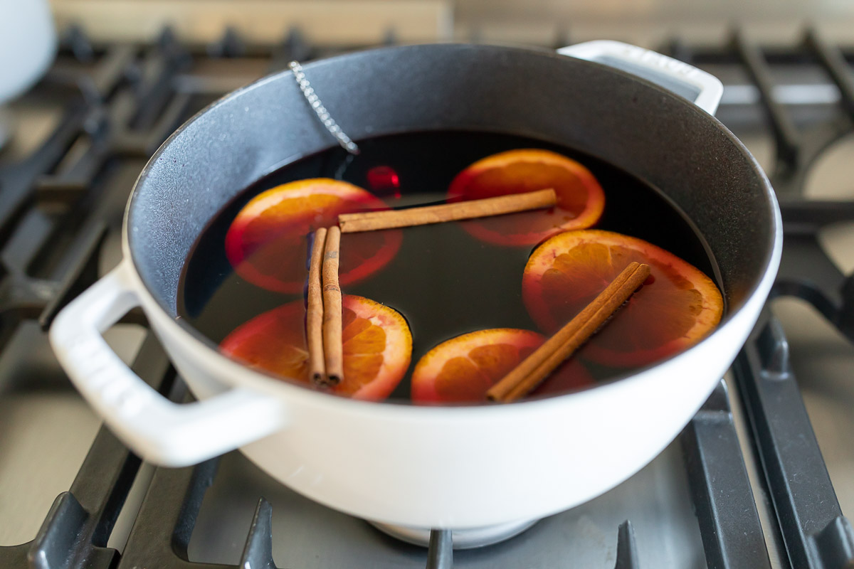 Mulled wine in a cast iron pot on a stovetop.