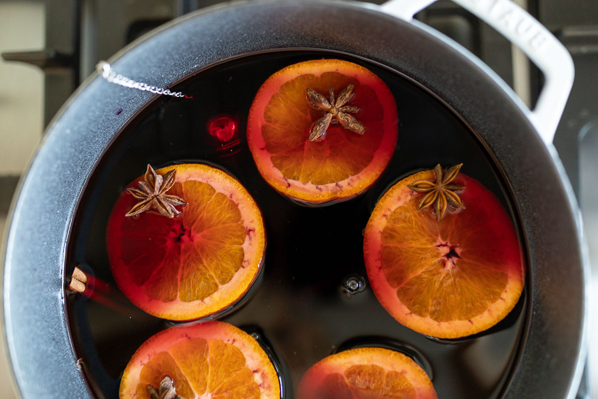 Mulled wine in a cast iron pot on a stovetop.