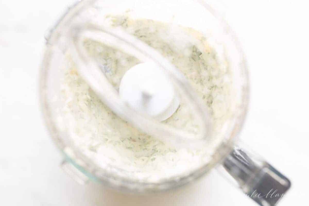 Looking inside a food processor, making pesto mayo.
