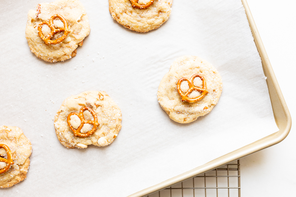 Kitchen sink cookies with pretzels, white chocolate and toffee on a baking sheet.