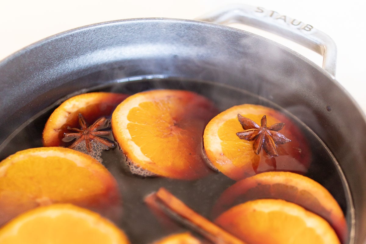 Mulled wine in a cast iron pot on a stovetop.