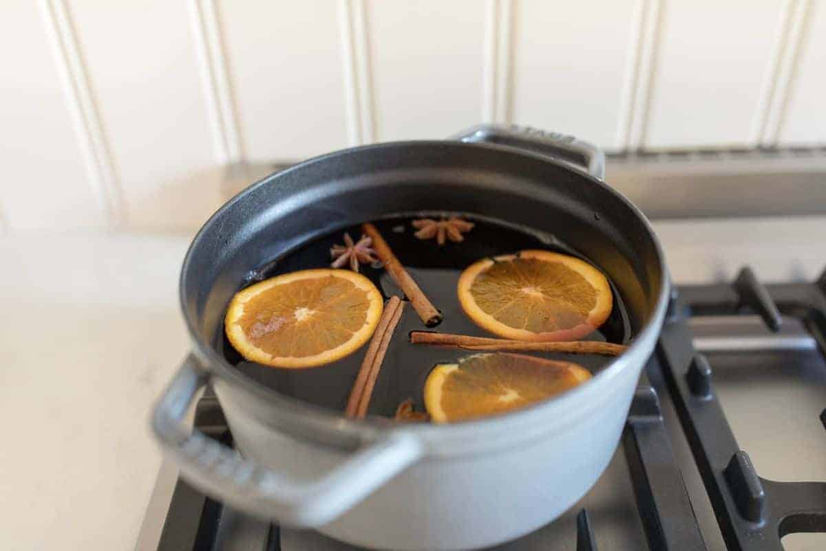 Mulled wine ingredients in a cast iron pot on the stovetop. 