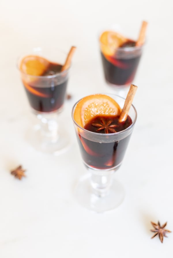Glasses of mulled wine garnished with cinnamon sticks.
