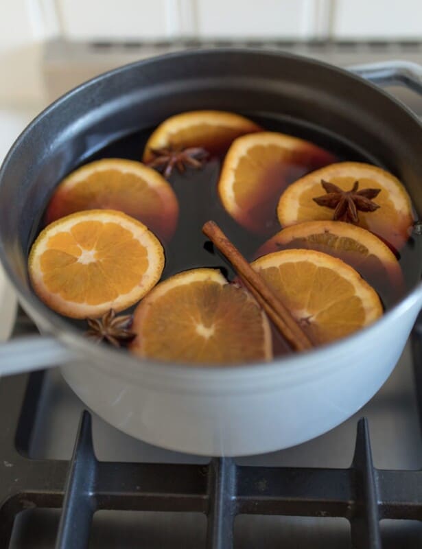 Gray enameled cast iron pot on stove top with mulled wine inside.