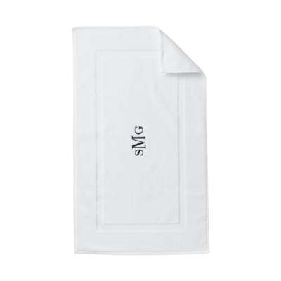 a white bath mat with blue embroidery
