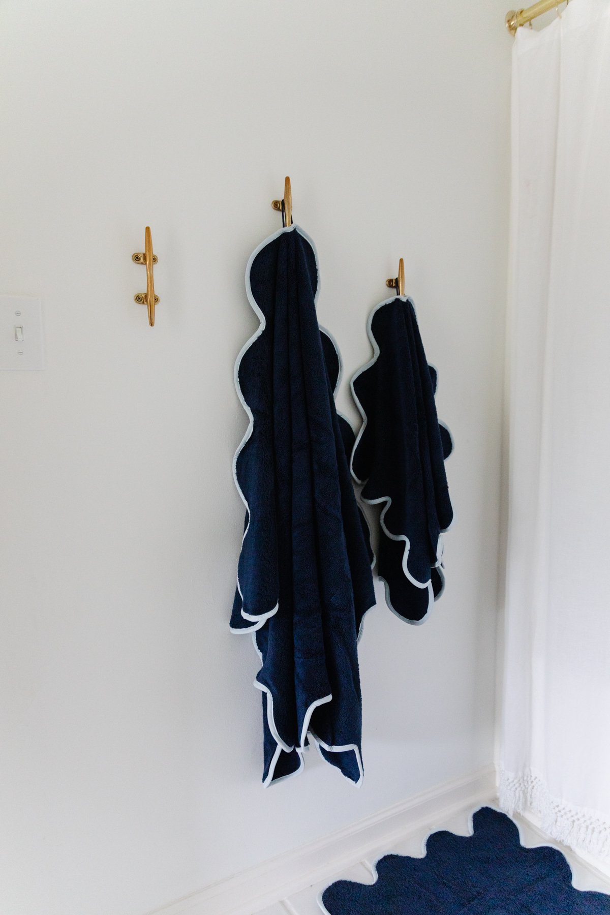 A nautical bathroom with two towels hanging on the wall.